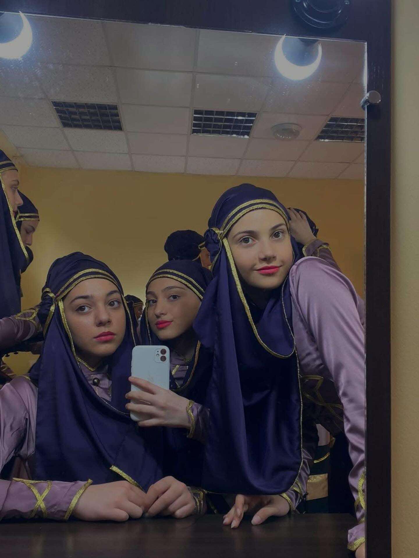 Young women in traditional Georgian dance costumes with blue headdresses
